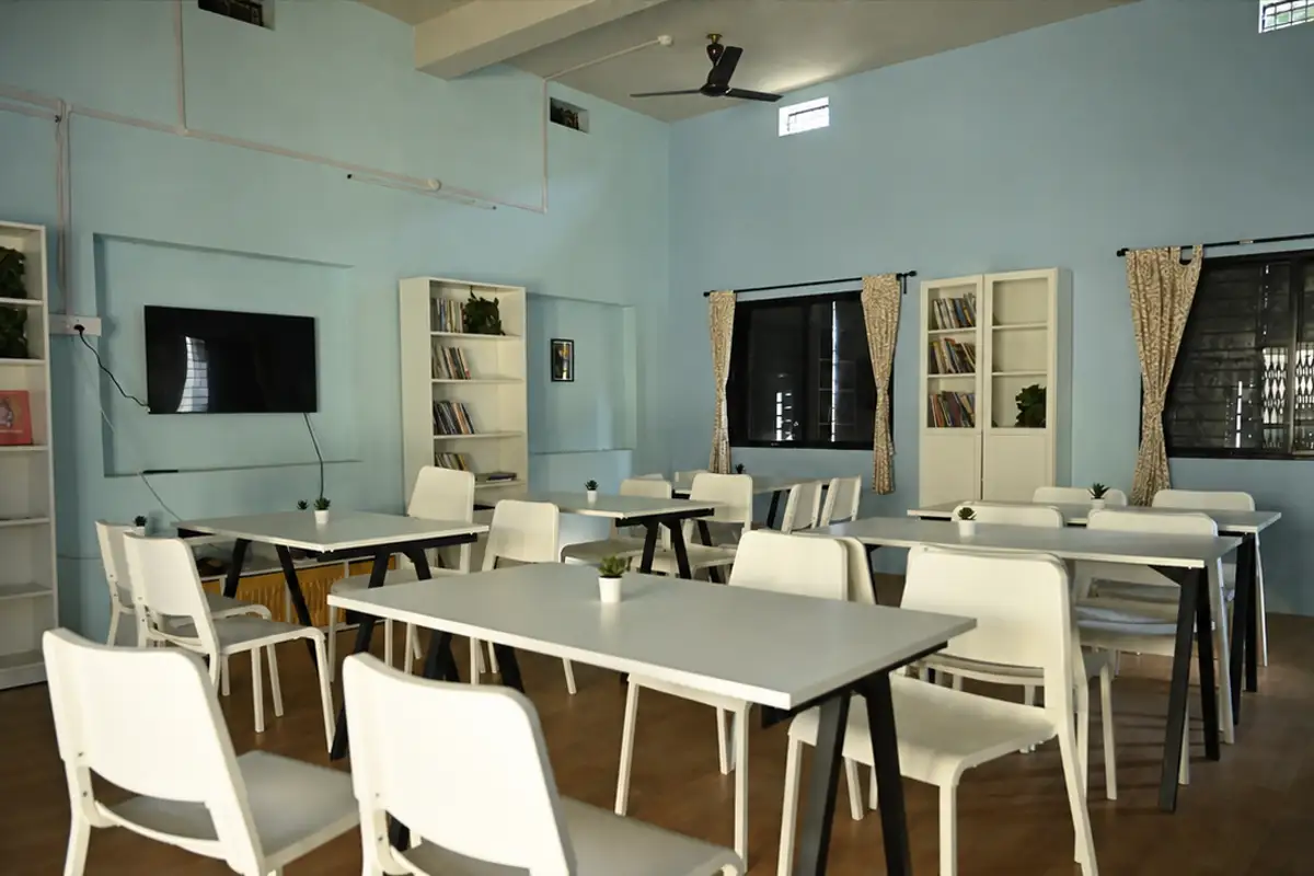 The Deolapar library after renewal, with bookshelves, white tables, chairs and blue walls