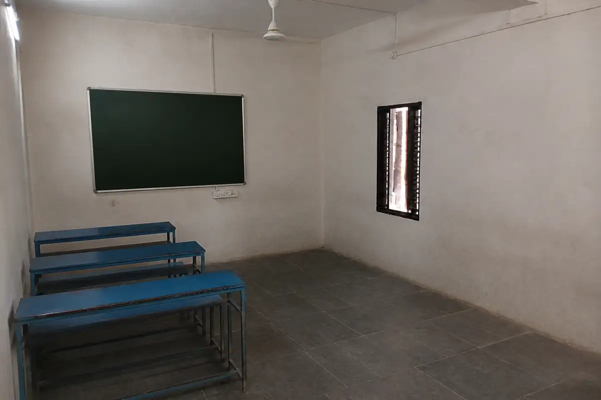 The Vihirgaon room before renewal, with worn walls, old benches and exposed electrical wiring